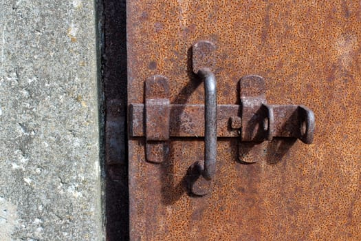 rusty iron prison door with deadbolt close to