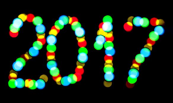 Happy New Year 2017 written blurred lights on a black background