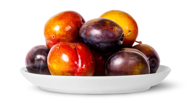 In front mix of red and violet plums on white plate isolated on white background