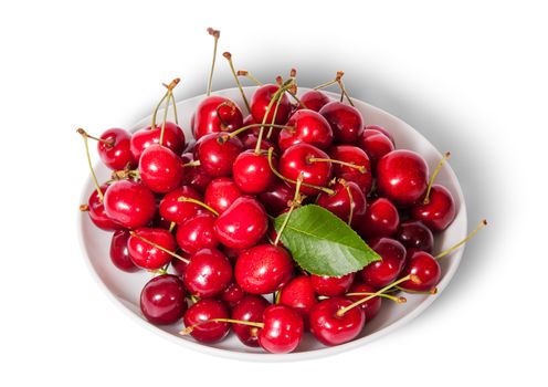 On top sweet cherries with leaf on white plate isolated on white background