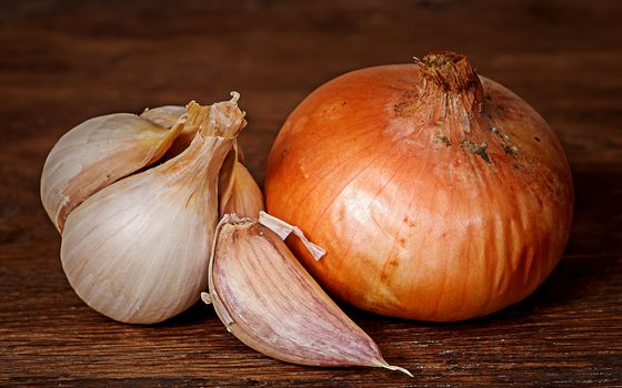 Closeup of onion and garlic on wooden table