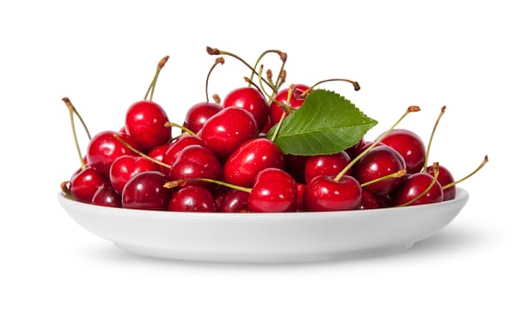 Pile of sweet cherries with leaf on white plate isolated on white background