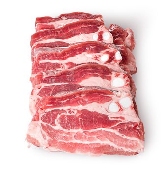 Raw pork belly slices in row isolated on white background
