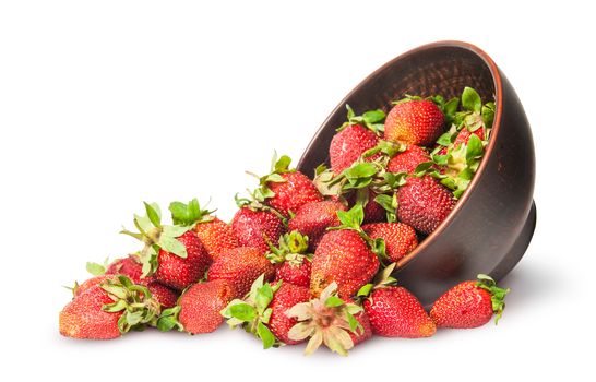 Scattered ripe juicy strawberries in a ceramic bowl isolated on white background