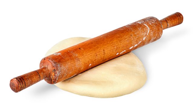 Rolling pin on piece of dough isolated on white background