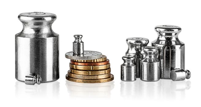 Several old scaling weights and coins isolated on white background