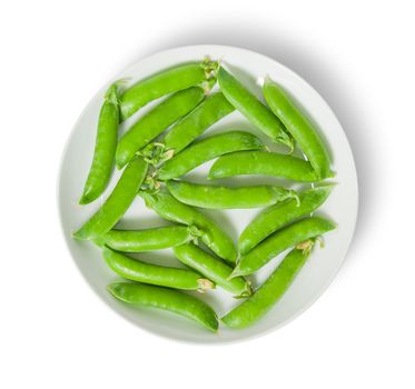 Several pods of peas on a white plate top view isolated on white background