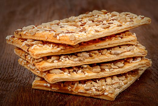 Stack of cereal cookies with seeds on a wooden table