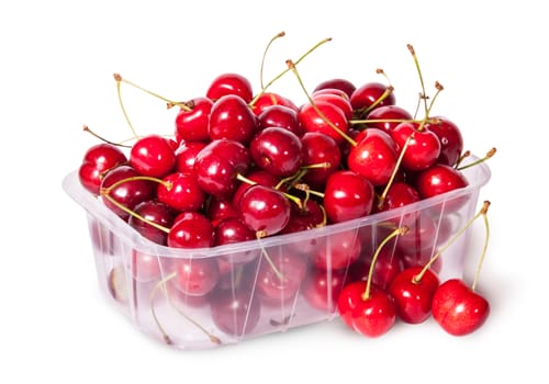 Sweet cherries in plastic tray and three near top view isolated on white background