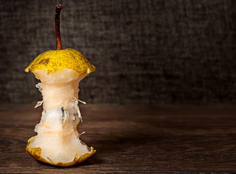 Stub of pear on wooden table background sacking