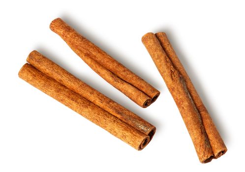 Three cinnamon sticks lie nearby isolated on white background