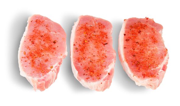 Three Pieces Of Raw Pork With Spices Isolated On White Background