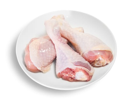 Three Raw Chicken Legs On White Plate Isolated On White Background