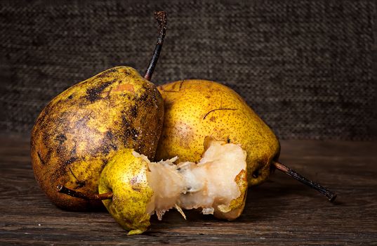 Two pears and stub on wooden table background sacking