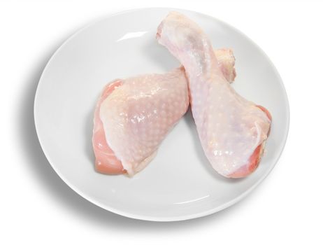 Two Raw Chicken Legs On White Plate Isolated On White Background