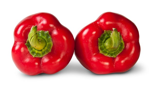 Two Red Bell Peppers Lying Beside Isolated On White Background