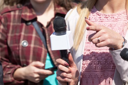 Female reporter holding microphone, conducting media interview