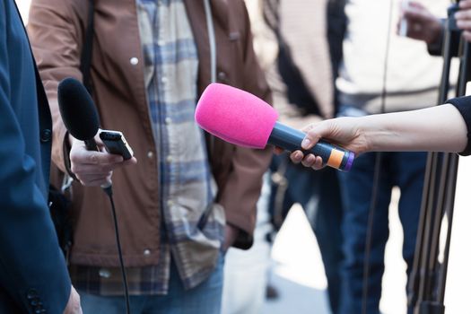 Reporters or journalists holding microphones, conducting television interview