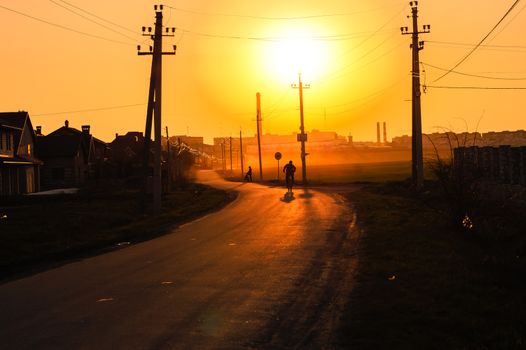 cyclists ride through the city at sunset beautiful landscape