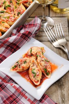 pasta conchiglioni shells stuffed meat mince with spinach and tomato sauce , Parmesan cheese, on a plate.  View from above.