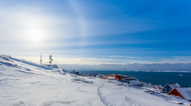 Arctic Sun Halo shining over houses at the fjord of Nuuk city, Greenland