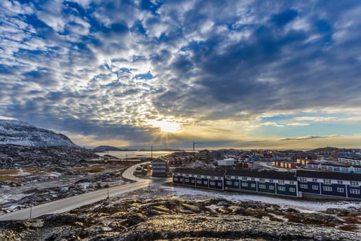 Arctic streets with houses on the rocky hills in sunset city panorama. Nuuk, Greenland