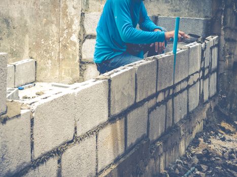 Manson or Brick builders are building walls in Thailand