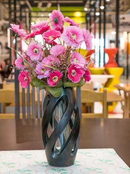 Bouquet of pink flower in vase on table with bokeh background