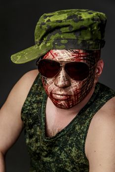 Portrait of Soldier with Military Style Camouflage on a  Face.  Portrait  on black background