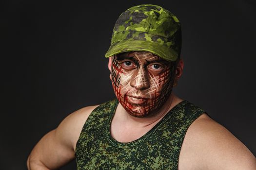 Portrait of Soldier with Military Style Camouflage on a  Face.  Portrait  on black background