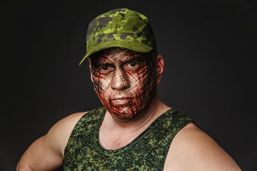 Portrait of Soldier with Military Style Camouflage on a  Face.  Portrait  on black background