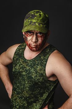 Portrait of Soldier with Military Style Camouflage on a  Face.  Portrait  on black background