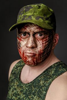 Portrait of Soldier with Military Style Camouflage on a  Face.  Portrait  on black background