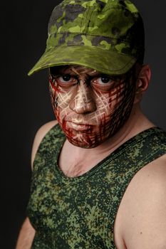 Portrait of Soldier with Military Style Camouflage on a  Face.  Portrait  on black background