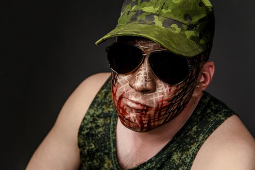 Portrait of Soldier with Military Style Camouflage on a  Face.  Portrait  on black background