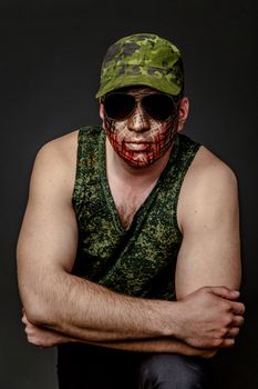 Portrait of Soldier with Military Style Camouflage on a  Face.  Portrait  on black background