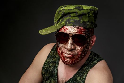 Portrait of Soldier with Military Style Camouflage on a  Face.  Portrait  on black background