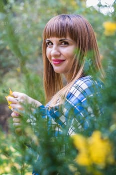 portrait of a beautiful, dreamy girl with long straight hair in a blue long dress in the park in autumn