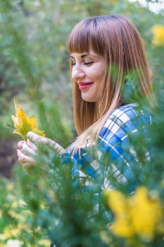 portrait of a beautiful, dreamy girl with long straight hair in a blue long dress in the park in autumn