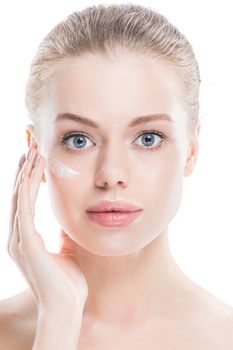 Beautiful young woman with cream on clean fresh face skin close up isolated on white background