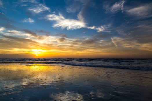 The sun rises at the beach on a cloudy morning over Amelia Island, Florida.