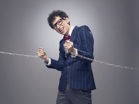 Funny businessman breaking metal chain with hands