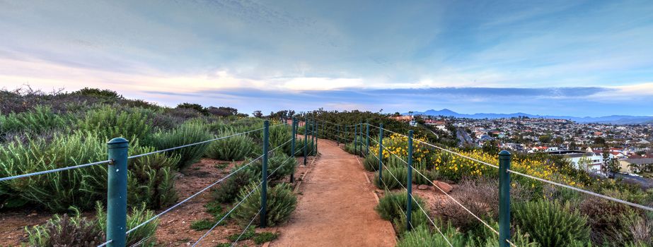 Hiking trail above Dana Point city view at sunset in Southern California, USA