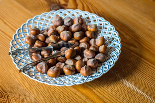Close up hazelnut. Fresh organic filbert in plate on wooden background
