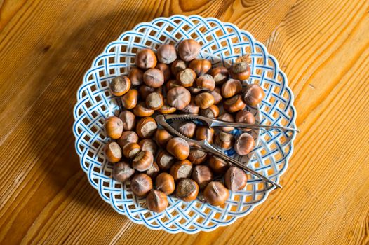 Close up hazelnut. Fresh organic filbert in plate on wooden background