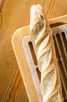 Close up french bread baguette on vintage wooden board with knife