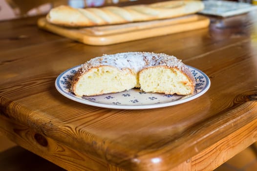 Close up brioche bread in a white plate on a wooden table. Baguette like fuzzy background