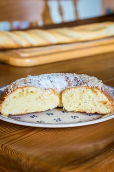 Close up brioche bread in a white plate on a wooden table. Baguette like fuzzy background