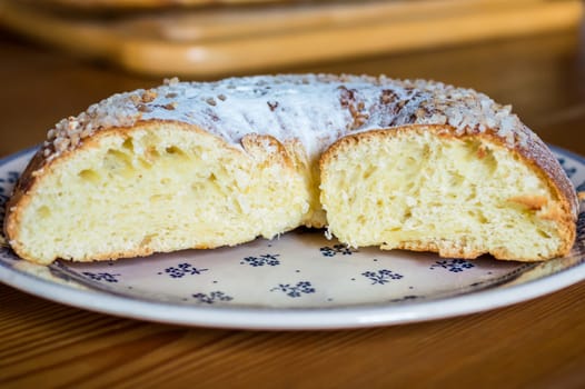 Close up brioche bread in a white plate on a wooden table. Baguette like fuzzy background