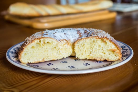 Close up brioche bread in a white plate on a wooden table. Baguette like fuzzy background